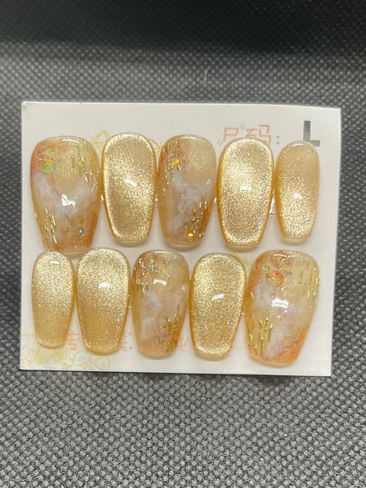 Sparkling gold glitter coffin nails with marble accents for a glamorous finish.